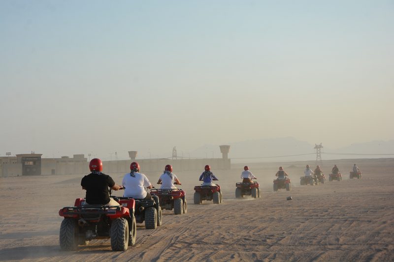 Quad convoy kicking up desert dust
